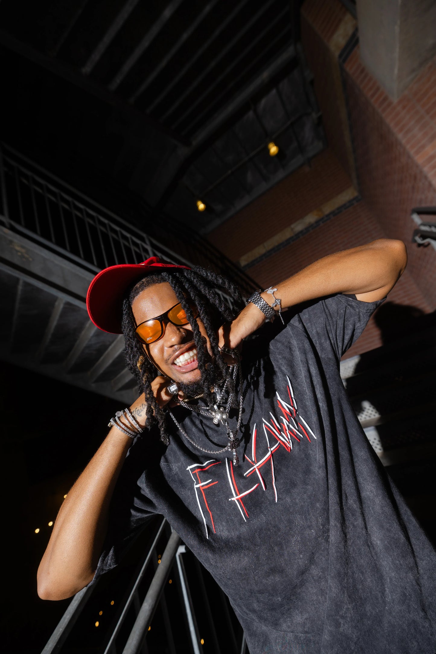 Oversized acid-washed black heavyweight tee with red "FLYAWY" graphic text on front.