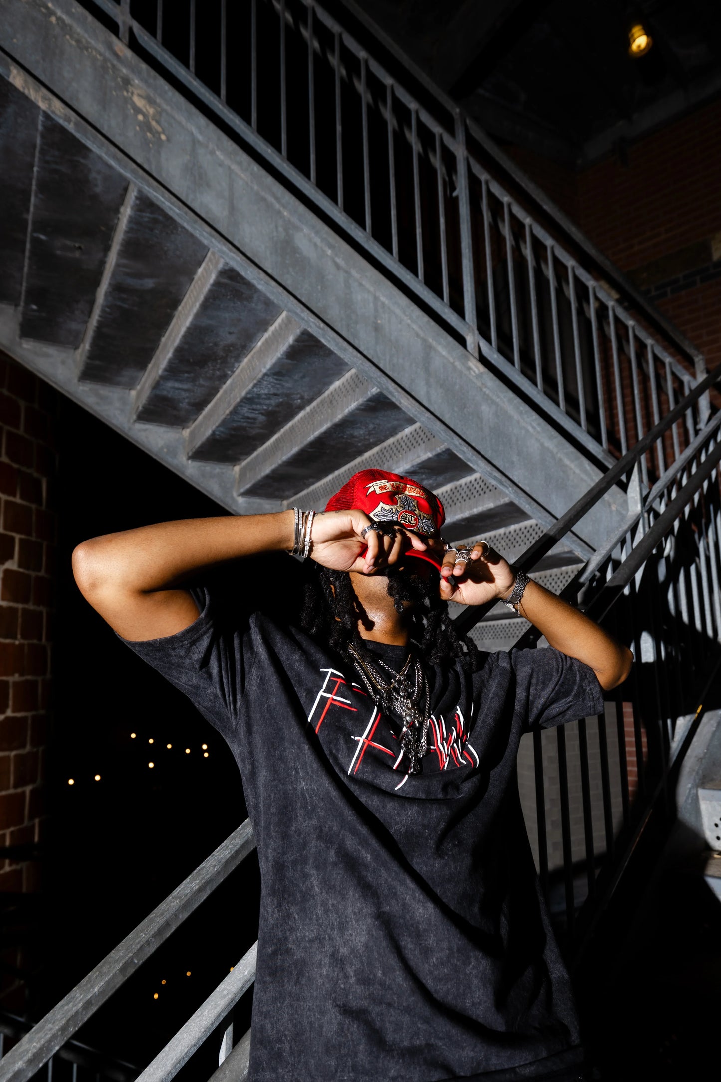 Oversized black acid-washed heavyweight tee with red "FLYAWAY" graphic text on front, streetwear style.