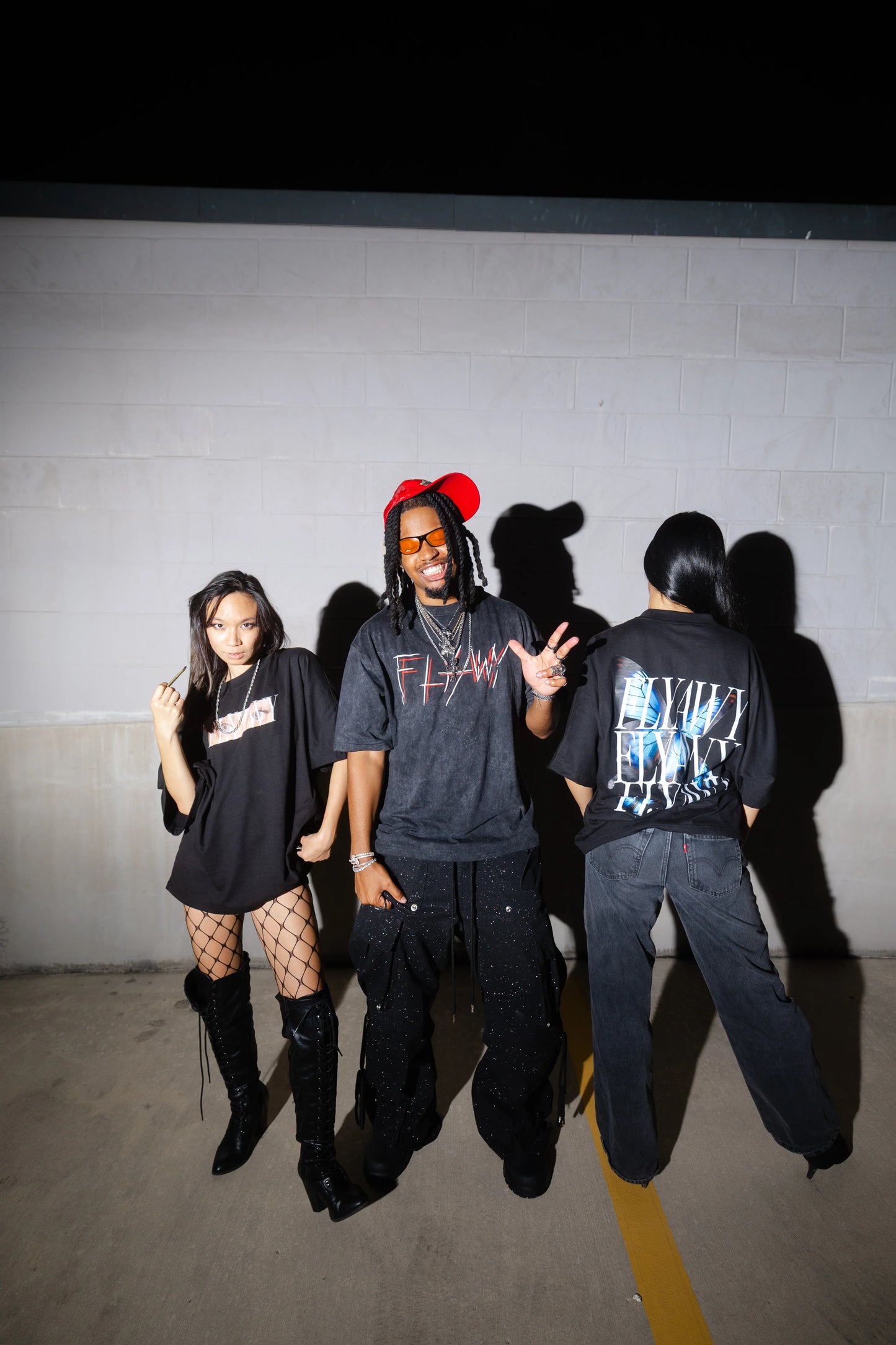 Oversized acid-washed black heavyweight tee with graphic text and abstract blue design on back, styled in streetwear look.