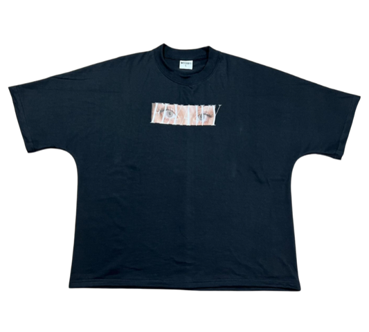 Oversized black heavyweight cotton tee with a rectangular graphic in white and light brown across the chest.