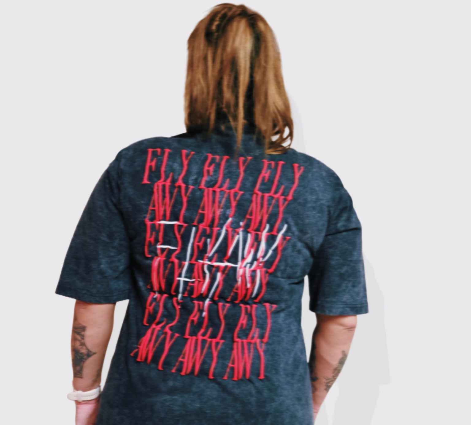 Oversized acid-washed heavyweight black tee with red "FLY AWAY" graphic text repeated on the back.